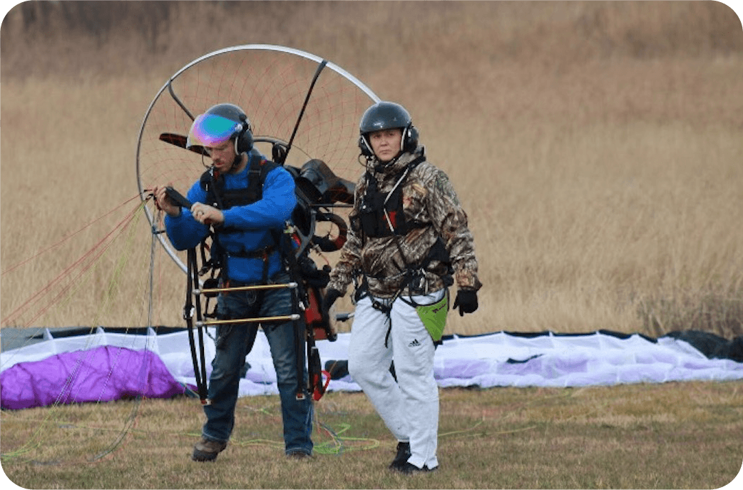 Two pilots ground-handling a wing on the training field at Paramotor Flyers.